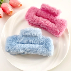 Close-up of pink and blue plush square hair claws with soft faux fur texture for winter