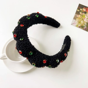 Close-up of black plush headband featuring red and green rhinestones in gold claw settings