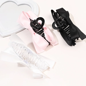 Détail de trois pinces à cheveux en satin rose, noir et blanc avec miroir en forme de cœur