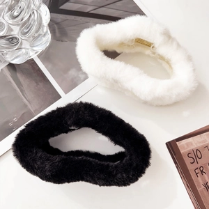 Close-up of black and white plush claw clips showing soft faux fur and metal spring detail