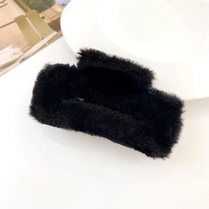 Close-up of square plush hair claw clip in black faux fur with soft fluffy texture