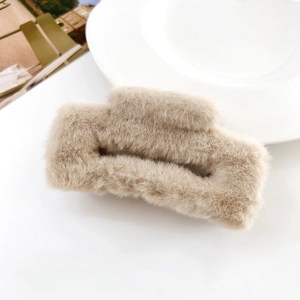Close-up of beige plush faux fur hair claw clip with a rectangular hollow design