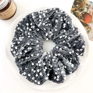 Detailed texture of grey velvet scrunchie with silver sequins and elegant aesthetic decor