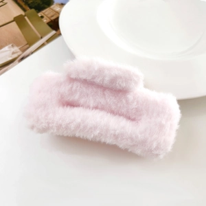 Close-up of pink plush hair claw clip featuring soft faux fur texture and rectangular design