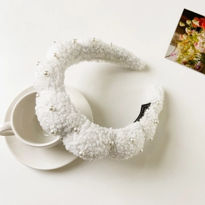 Macro detail of white plush headband with pearls and chunky sponge texture for women