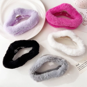 Close-up of five colorful plush hair claws in black, white, grey, purple and rose red