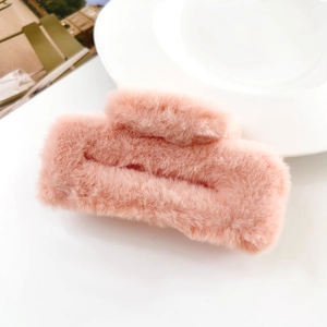 Detail of pink plush claw clip showing soft faux fur texture and elegant square design