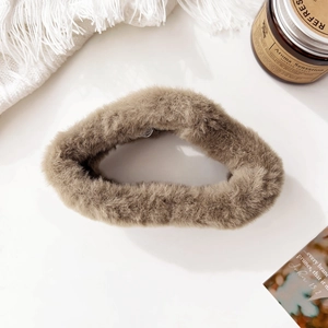 Detailed view of large plush khaki shark hair claw clip with fluffy faux fur texture