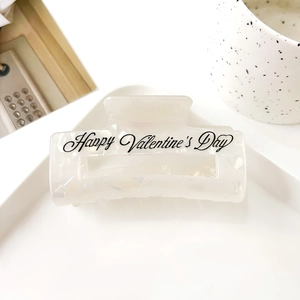 Détail de la pince à cheveux nacrée blanche de Saint-Valentin avec texte thématique écrit