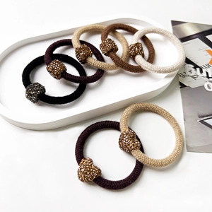 Detail of multi-color elastic hair ties with sparkling rhinestone beads on a tray