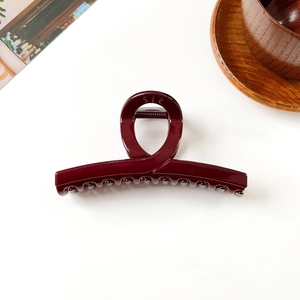 Détail d'une pince à cheveux bordeaux montrant la finition résine et le ressort solide