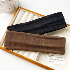 Close-up of black and brown elastic knitted sports headbands with fine ribbed texture