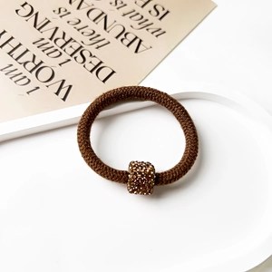 Detail of high-elastic coffee hair tie with a square gold rhinestone-encrusted buckle