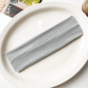 Detail shot of light grey knitted yoga headband with soft elastic texture on white plate