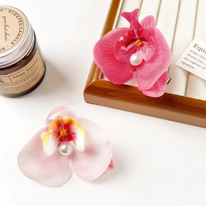 Detail of pink orchid hair clips with pearls on a decorative lifestyle background
