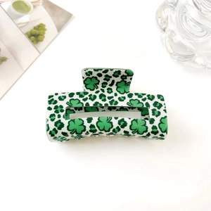 Détail d'une pince à cheveux rectangulaire avec motif trèfle vert et imprimé léopard