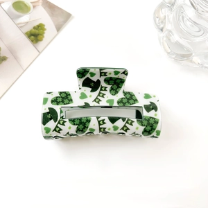 Vue détaillée de la pince à cheveux carrée avec motifs de trèfle vert et de cœur