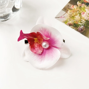 Detail of pink gradient orchid hair clip with pearl center and silver metal duckbill clip