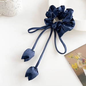 Detail of navy blue satin scrunchie with long ribbons and tulip fabric charms