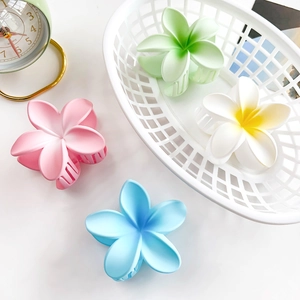 Detail view of multi-color matte flower hair claws in pink, green, and blue hues