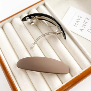 Barrettes à cheveux ovales mates minimalistes en noir et marron sur velours blanc