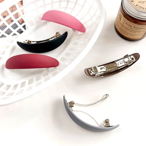 Gros plan de barrettes ovales mates de diverses couleurs dont rose, bordeaux et gris