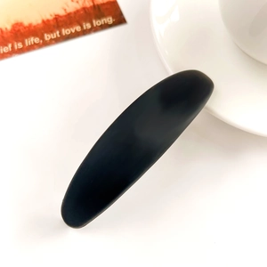 Détail de la pince à cheveux ovale allongée noir mat avec mécanisme à ressort épuré