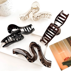 Set of four geometric wavy shark hair clips in amber, black, and transparent resin