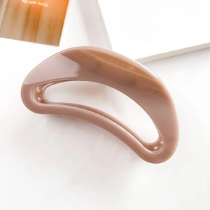 Close-up of the smooth wavy lines and polished texture of the large milk tea hair claw