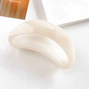 Detailed top view of large cream resin crescent hair claw clip on aesthetic tray