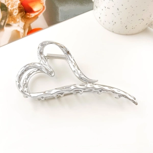 Detail of liquid metal heart hair claw clip with hammered texture and silver finish
