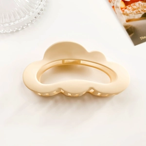 Close-up of a matte cream cloud hair claw clip on a minimal white background