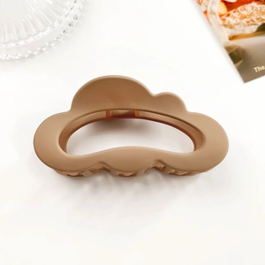 Close-up of matte camel cloud-shaped hair claw clip with elegant hollow-out design