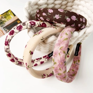Lot de quatre serre-têtes en tissu floral rétro disposés dans un panier tressé blanc