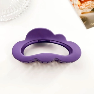 Detail view of purple matte cloud hair claw clip on a minimalist aesthetic background