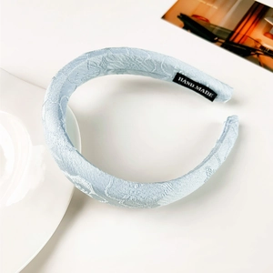Détail d'un serre-tête en tissu jacquard bleu clair avec étiquette faite main