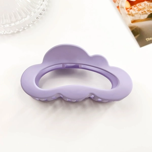 Detail shot of a matte purple cloud-shaped claw clip with hollow design for hair styling