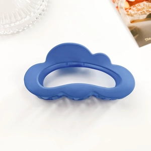 Close-up of matte royal blue cloud-shaped hair claw clip with frosted texture and spring