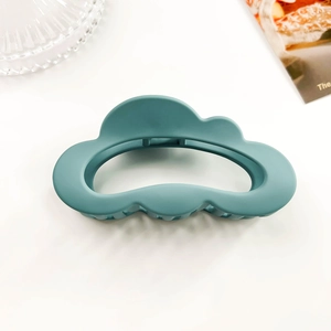 Close-up of matte cloud-shaped hair claw clip in morandi teal with frosted finish