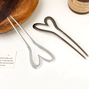 Detailed view of silver and gunmetal U-shaped hair pins with heart-shaped metal design