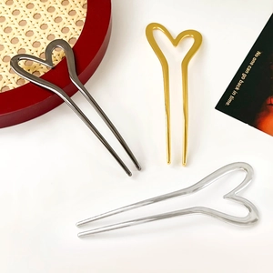 Close-up of minimalist U-shaped metal hairpins in gold, silver and gun black finishes