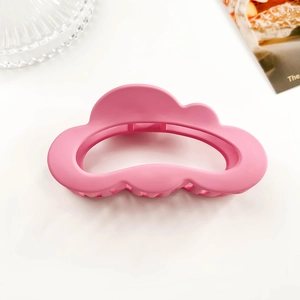 Close-up of matte pink cloud-shaped hair claw clip with a sleek frosted finish