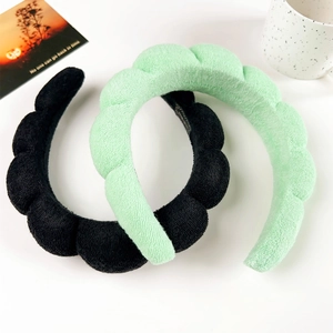 Detail showing plush padded sponges headbands in black and mint green wavy design