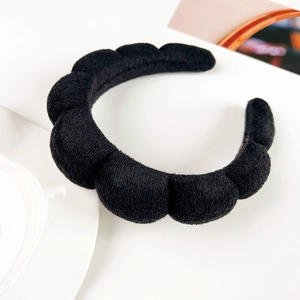 Detail view of black puffy flannel headband with soft sponge filling and quilted pattern