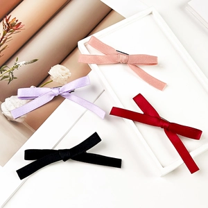 Detail showing various colors of ribbon bow hair clips on a white frame decorative tray