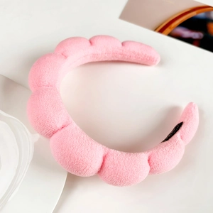Close-up of pink flannel cloud headband showing soft plush texture and wavy design