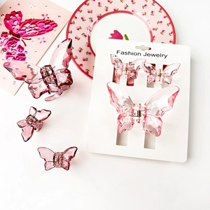 Macro detail of translucent pink butterfly hair claws on elegant floral display