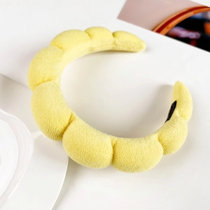Detail of yellow puffy sponge headband with textured terry cloth and soft bubble design