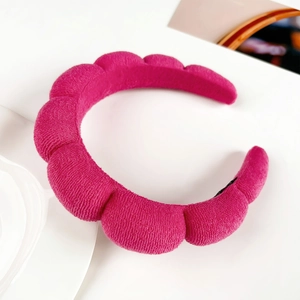 Detail view of the fuchsia padded headband with wave texture for skin care and styling