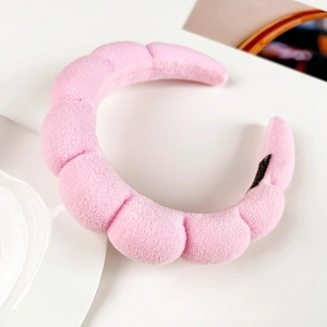 Detail showing the pink plush sponge headband with textured fabric and wave-like surface design